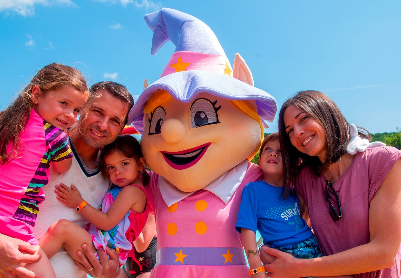 Familia sonriente con la mascota del camping CAPFUN Fumades en ALLEGRE-LES-FUMADES (30).