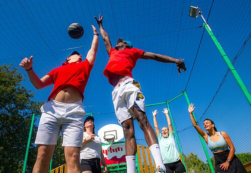 Jugadores de baloncesto en partido en cancha multideporte en camping CAPFUN Fumades.