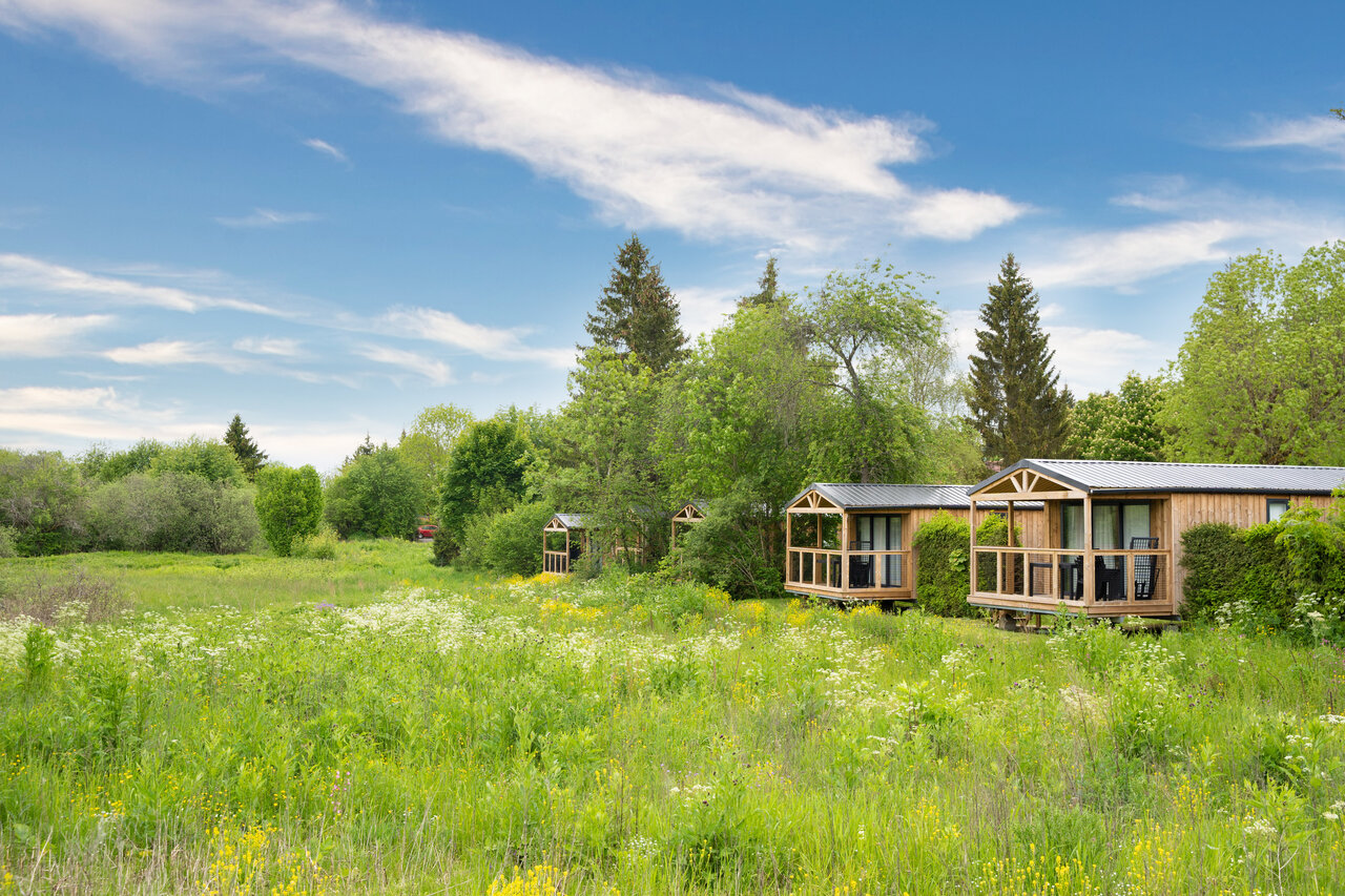 Mobil-homes de madera con terrazas, naturaleza verde en el camping CAPFUN Fuvettes en Malbuisson (25).