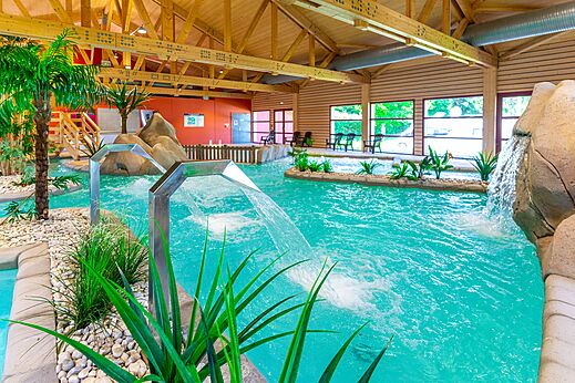 Piscina cubierta con chorros de agua y decoraci�n tropical en el camping CAPFUN Fuvettes en Malbuisson (25).
