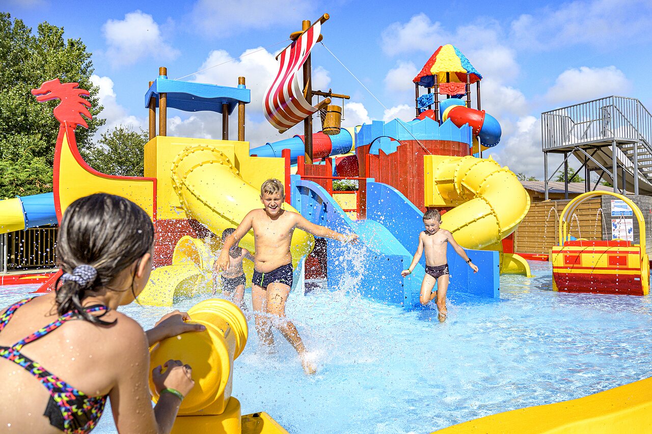 Parque acu�tico con toboganes, juegos de agua y ni�os felices en camping CAPFUN Golf en SAINT JEAN DE LA RIVIERE (50).