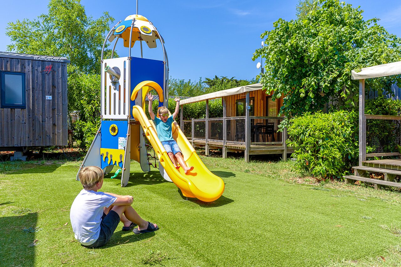 �rea de juegos con tobog�n en el camping CAPFUN Golf en SAINT JEAN DE LA RIVIERE (50).