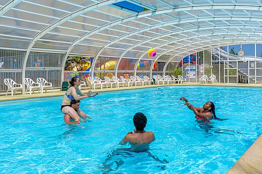 Piscina cubierta, baño y juegos en el camping CAPFUN Golf en SAINT JEAN DE LA RIVIERE.