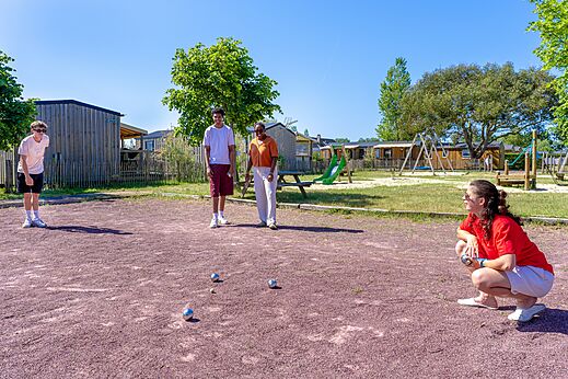 Partida de petanca familiar en la cancha del camping CAPFUN Golf en SAINT JEAN DE LA RIVIERE (50).