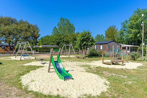 Zona de juegos con tobogán y columpios en el camping CAPFUN Golf, SAINT JEAN DE LA RIVIERE (50).