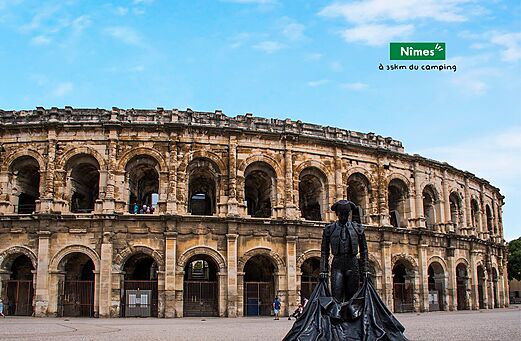 Anfiteatro romano de Nîmes y estatua de torero, lugar para visitar cerca del camping.
