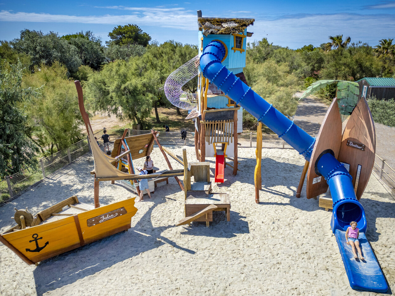Zona de juegos infantil con toboganes y estructuras de barco en el camping CAPFUN Grande Cosse en Saint Pierre la Mer (11).