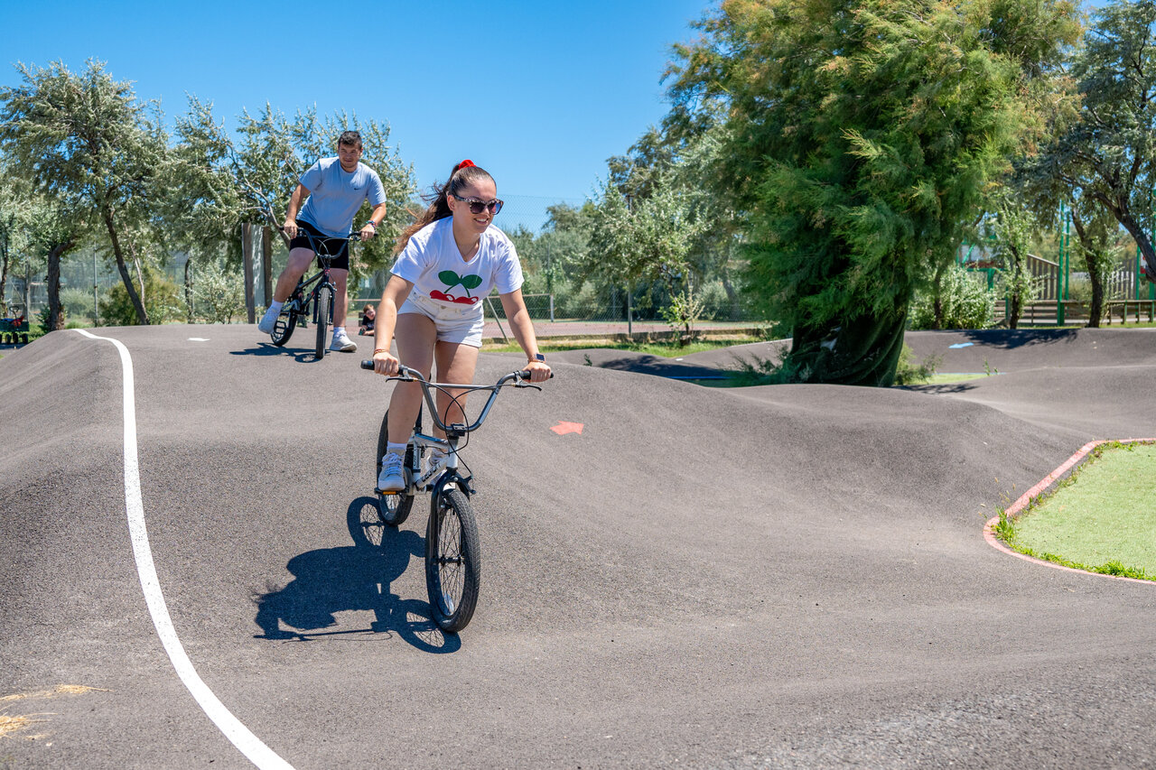 Pista de pump track con dos ciclistas en el camping CAPFUN Grande Cosse.