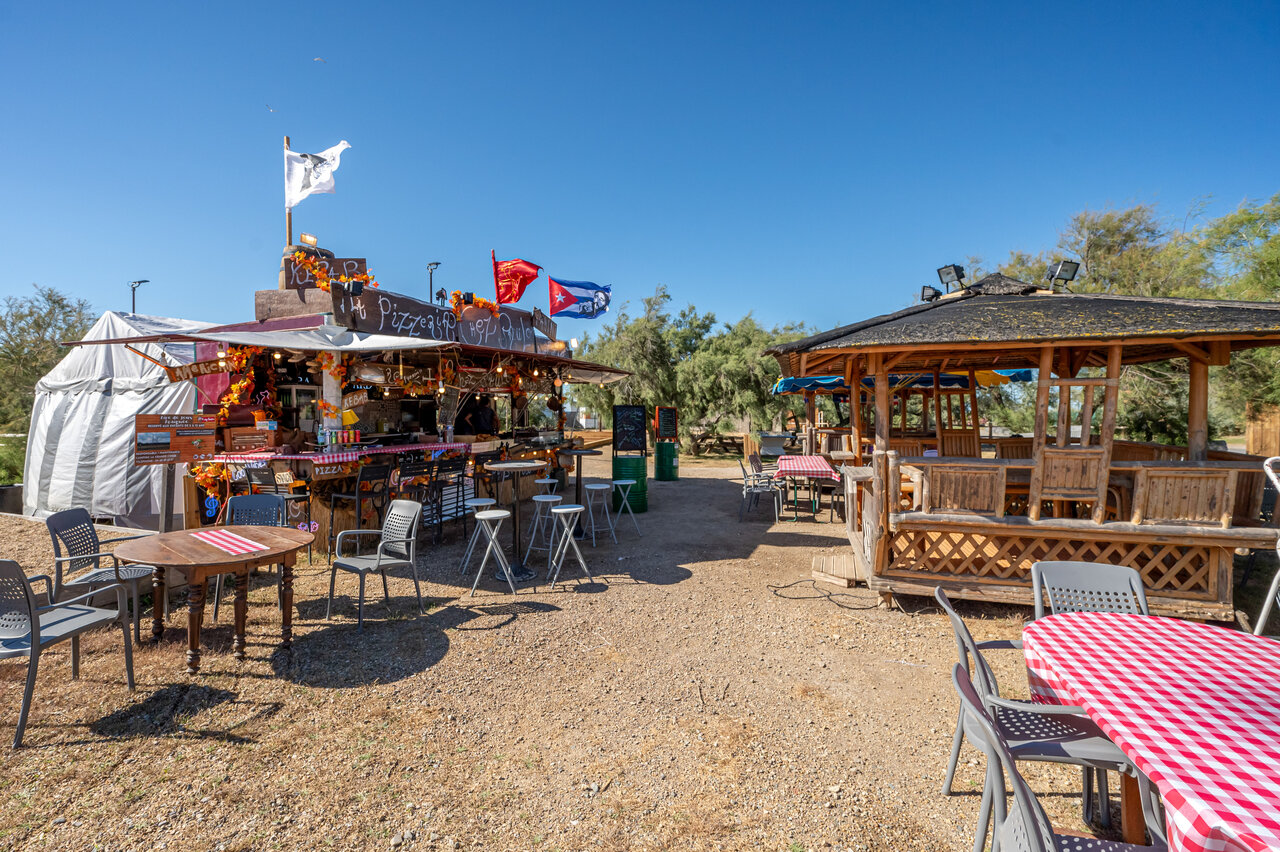 Pizzer�a restaurante exterior con mesas y sillas en el camping CAPFUN Grande Cosse en Saint Pierre la Mer (11).