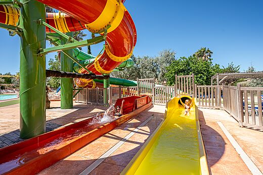 Toboganes acu�ticos coloridos y ni�os divirti�ndose en el camping CAPFUN Grande Cosse en Saint Pierre la Mer (11).