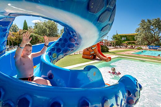 Ni�o en tobog�n acu�tico azul y piscina en el camping CAPFUN Grande Cosse en Saint Pierre la Mer (11).