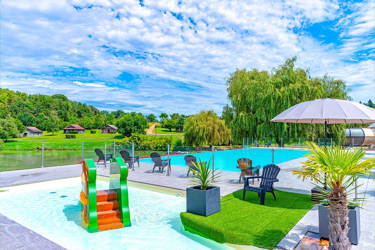 Piscina exterior con tobog�n infantil y tumbonas en el camping CAPFUN Grand Cerf en Gimouille (58).