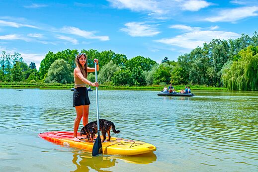 Paddleboard con mujer y perro en el lago, camping CAPFUN Grand Cerf.