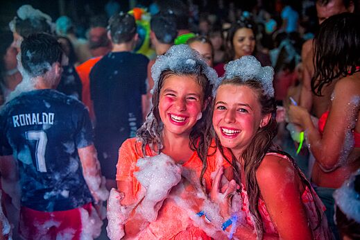 Dos chicas sonrientes disfrutando de una fiesta de espuma animada en el camping CAPFUN Grand Cerf en Gimouille (58).