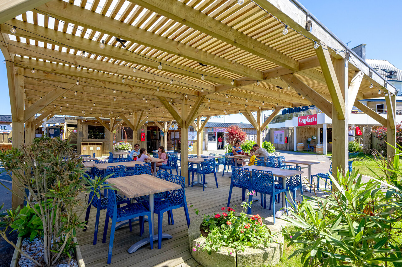 Terraza sombreada restaurante, mesas azules, camping CAPFUN Grand Large FOUESNANT (29).
