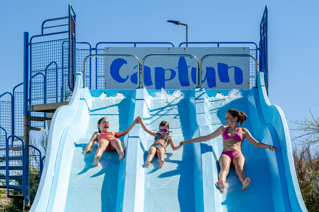 Ni�os felices en tobog�n acu�tico multipista en el camping CAPFUN Grand Large en FOUESNANT (29).