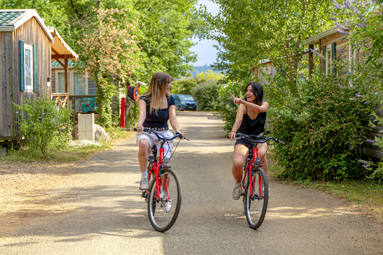 Amigas en bicicleta por sendero, mobil-homes, en camping CAPFUN Grand Lierne en CHATEAUDOUBLE.