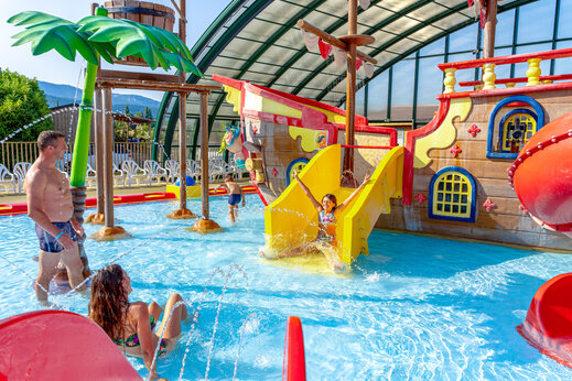 Zona acuática cubierta con barco pirata, toboganes y juegos de agua en el camping CAPFUN Grand Lierne en CHATEAUDOUBLE (26).