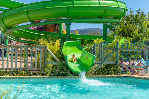 Tobogán verde, niño y piscina en el camping CAPFUN Grand Lierne en CHATEAUDOUBLE (26).