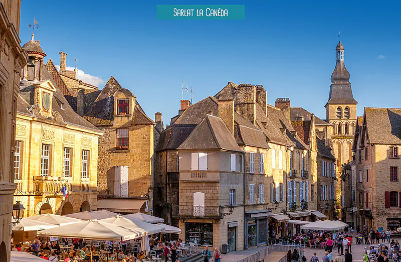 Plaza hist�rica animada de Sarlat-la-Can�da, Dordo�a, con terrazas de cafeter�as.