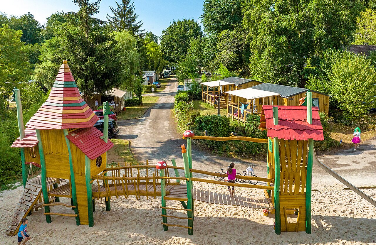 Parque infantil de madera con tobog�n y arena en el camping VAGUES OCEANES Granges en GROLEJAC (24).