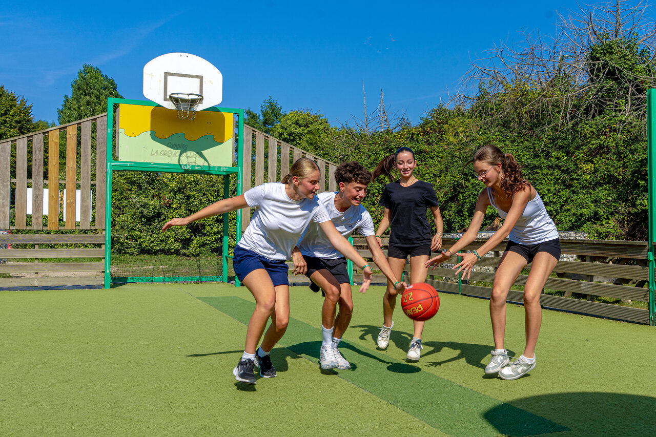 J�venes jugando baloncesto en cancha multideporte en camping CAPFUN Grenouill�re en Su�vres (41).