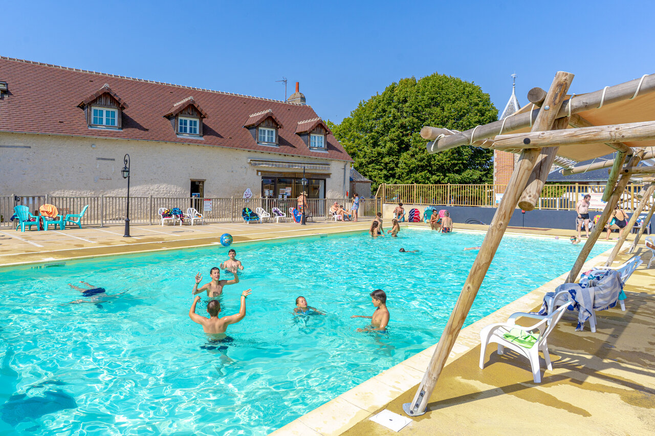 Piscina exterior animada con ni�os jugando a la pelota en el camping CAPFUN Grenouill�re en Su�vres (41).