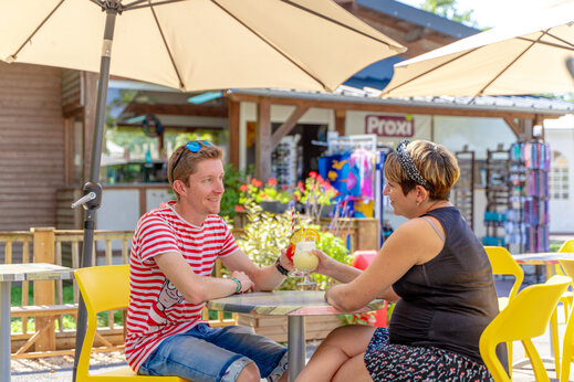 Pareja disfrutando cócteles en terraza, tienda Proxi en camping CAPFUN Grenouillère en Suèvres (41).