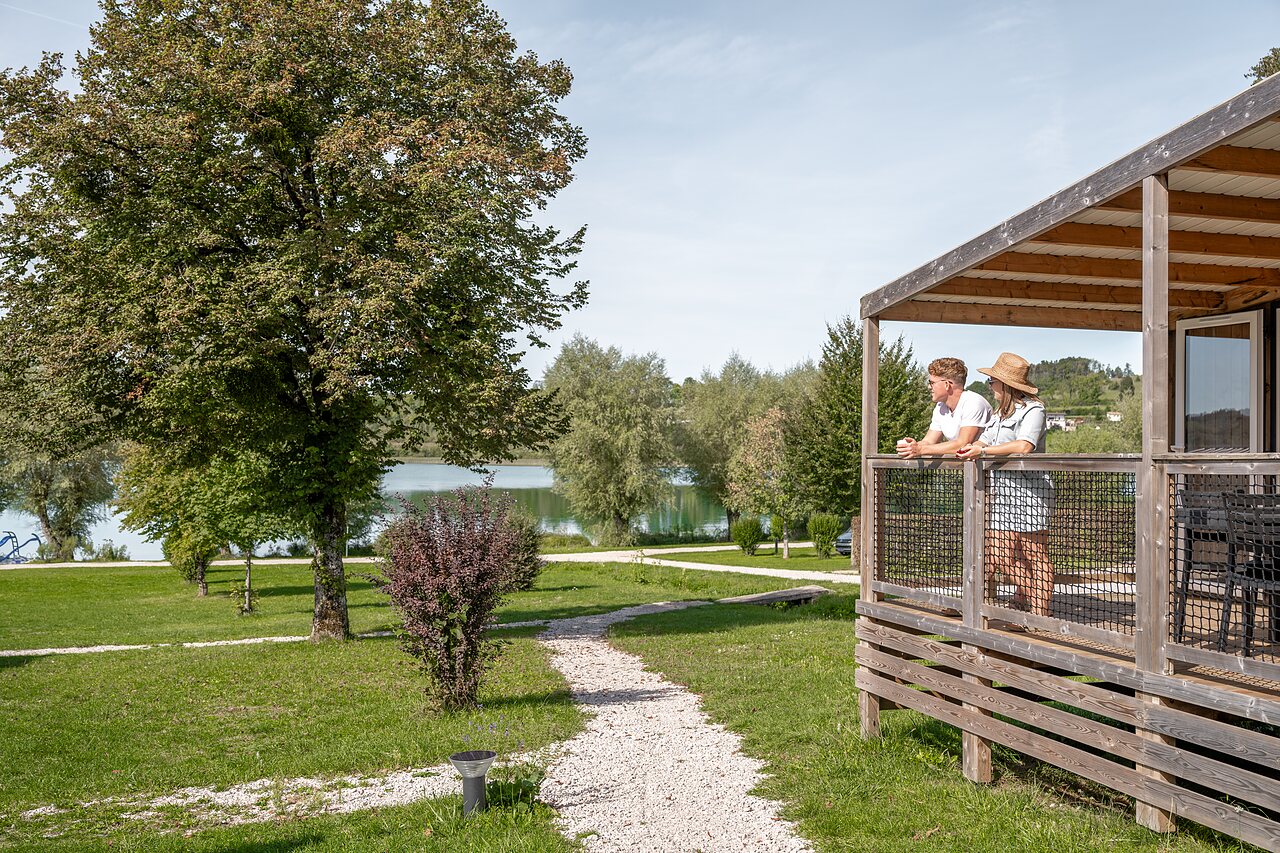 Pareja en terraza mobil-home, vista lago en camping CLICOCHIC Grisi�re, Clairvaux-les-Lacs.