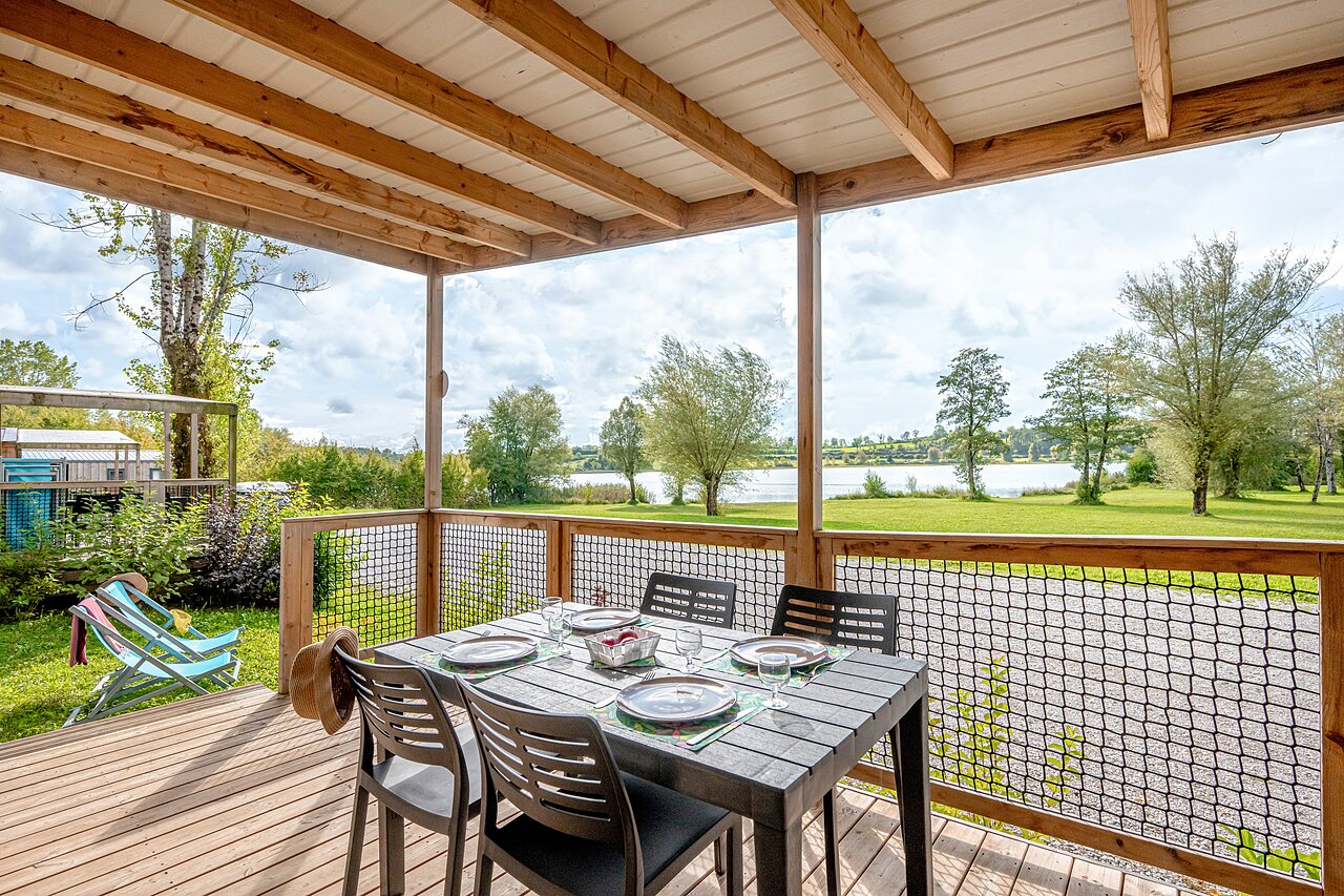 Terraza alojamiento, mesa puesta, vista lago en el camping CLICOCHIC Grisi�re en Clairvaux-les-Lacs.