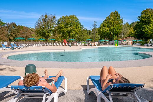 Piscina exterior, zona de relax en el camping CLICOCHIC Grisière en Clairvaux-les-Lacs.