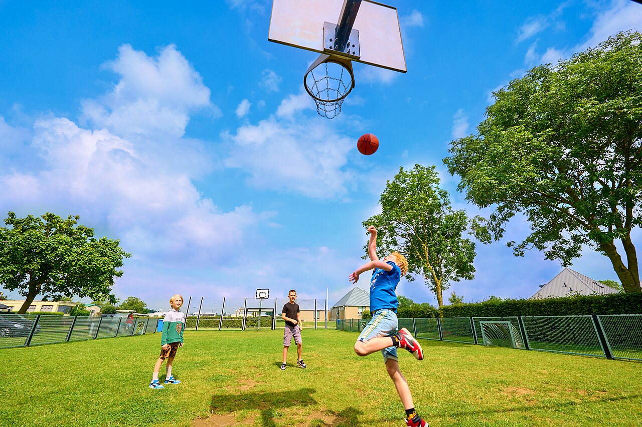 Ni�os jugando baloncesto en cancha multideporte en el camping CAPFUN Groene Eiland en Appeltern.