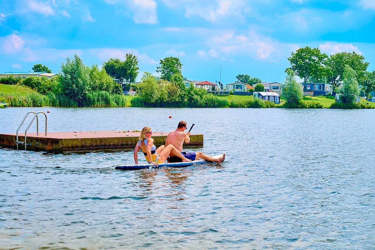 Pareja en paddleboard en el lago del camping CAPFUN Groene Eiland en Appeltern.