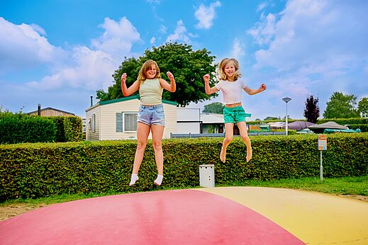 Dos ni�os saltan en coj�n hinchable gigante en camping CAPFUN Groene Eiland Appeltern.
