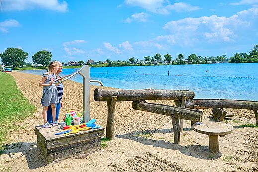 Playa de arena con juegos de agua y niños en el camping CAPFUN Groene Eiland en Appeltern.
