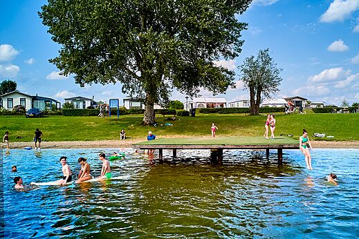 Playa de lago con pontón y baño en el camping CAPFUN Groene Eiland en Appeltern.