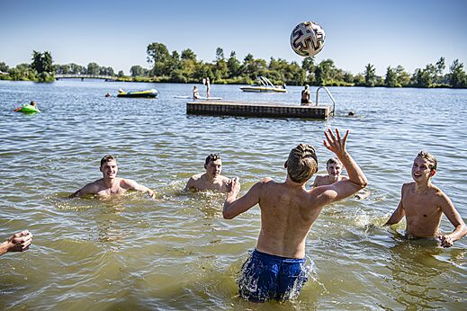 J�venes jugando voleibol en el agua del lago en el camping CAPFUN Groene Eiland en Appeltern.
