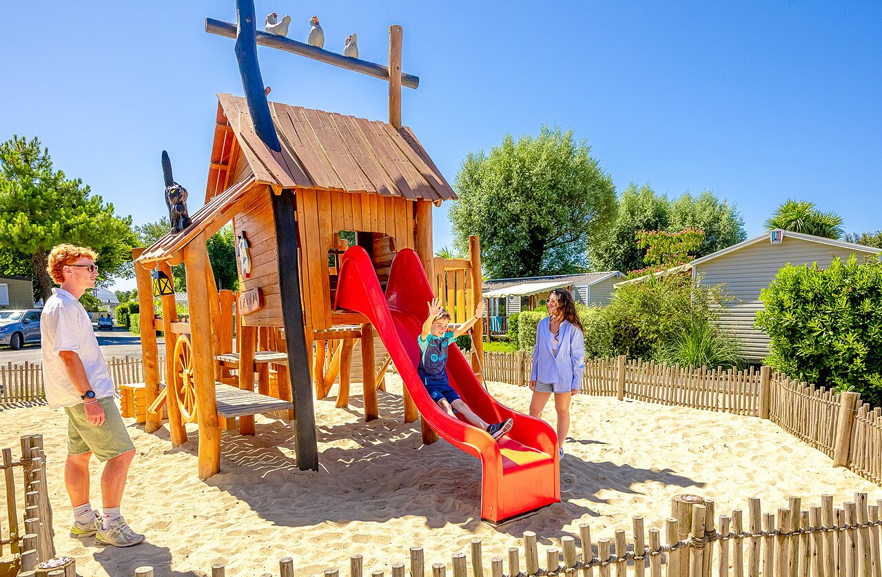 Zona de juegos de madera, tobog�n, ni�os en el camping VAGUES OCEANES Grosses Pierres.