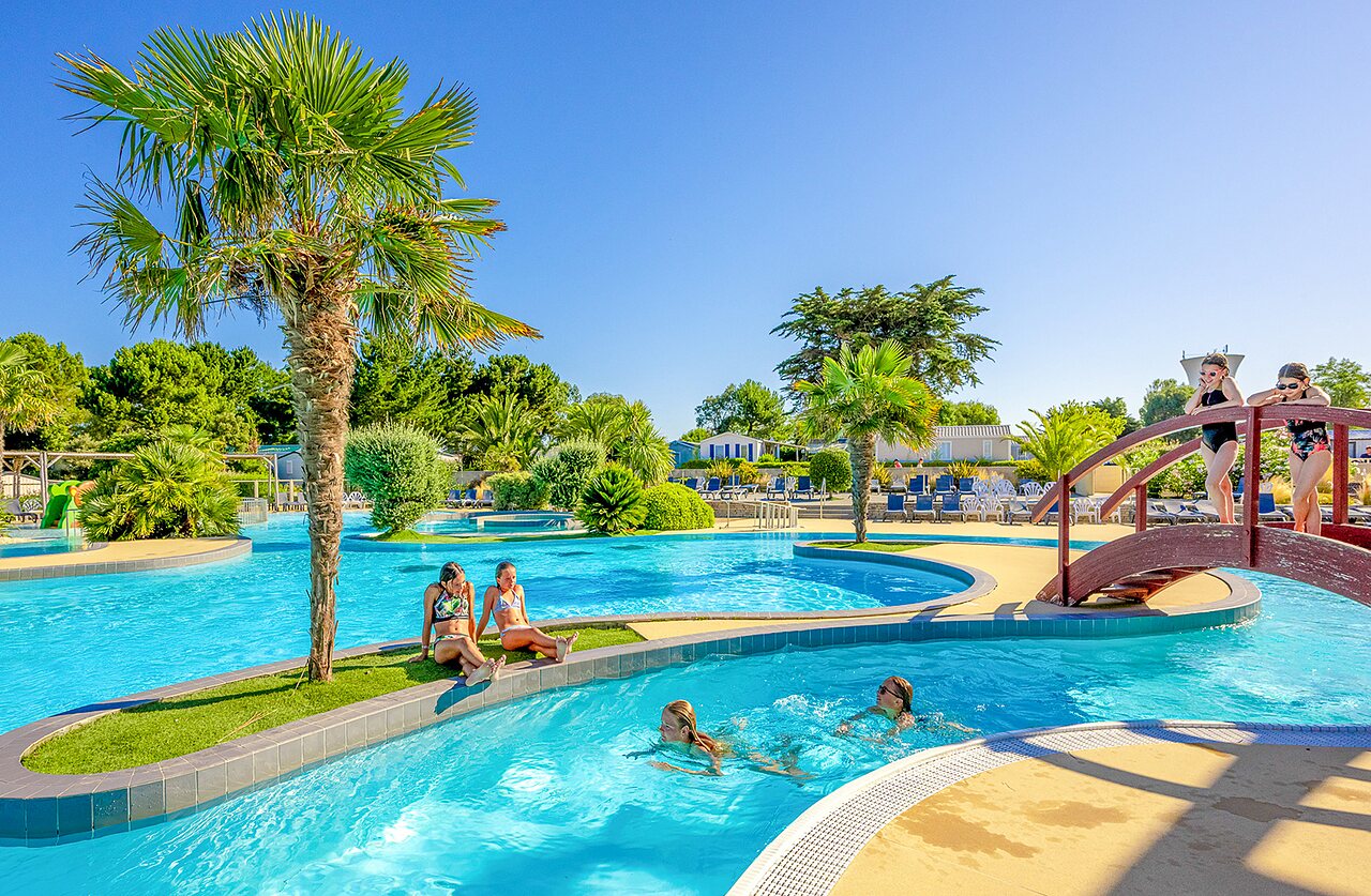 Piscina exterior, r�o y palmeras en el camping VAGUES OCEANES Grosses Pierres.