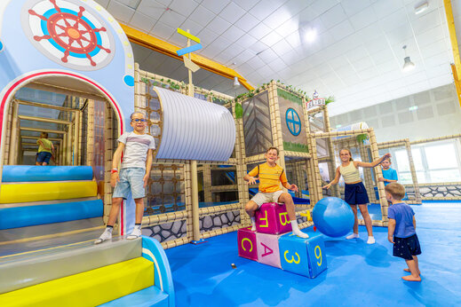 Zona de juegos interior con estructuras y niños en el camping VAGUES OCEANES Grosses Pierres en Saint-Georges-d'Oléron (17).