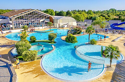 Gran zona acuática con piscinas y tobogán en el camping VAGUES OCEANES Grosses Pierres en Saint-Georges-d'Oléron.
