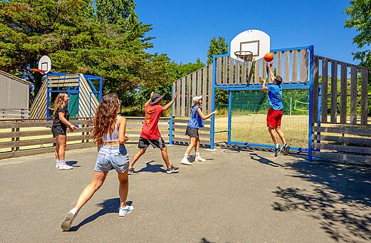 Jóvenes jugando baloncesto en la cancha multideportiva del camping VAGUES OCEANES Grosses Pierres en Saint-Georges-d'Oléron.