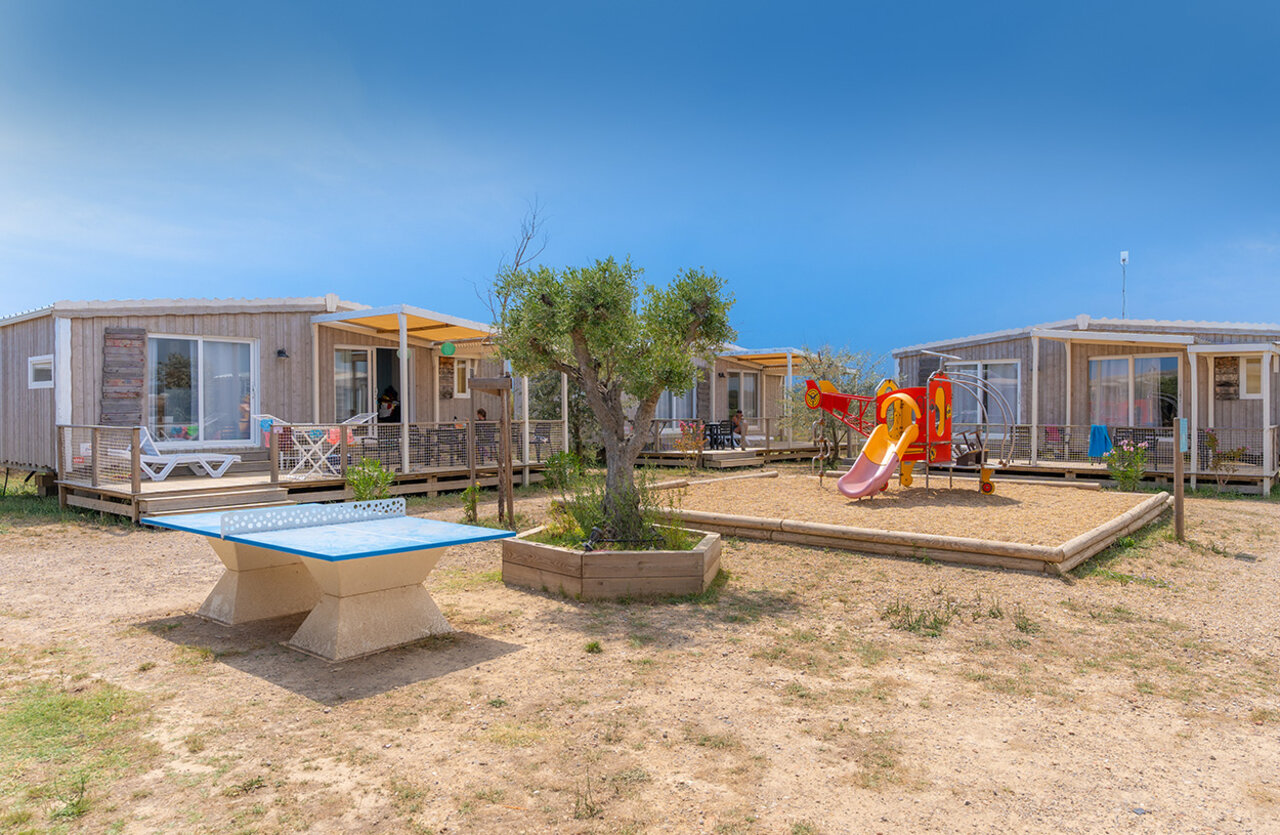Mobil-homes con terrazas, parque infantil y mesa de ping-pong en el camping VAGUES OCEANES Hamacs en Fleury (11).