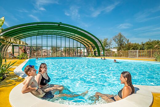 Piscina exterior y cubierta con bañistas en camping VAGUES OCEANES Hamacs en Fleury (11).