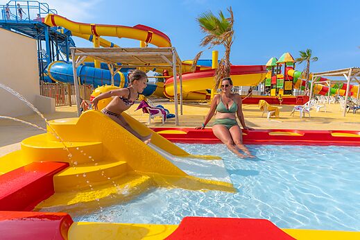 Toboganes acuáticos coloridos y piscina infantil en el camping VAGUES OCEANES Hamacs.