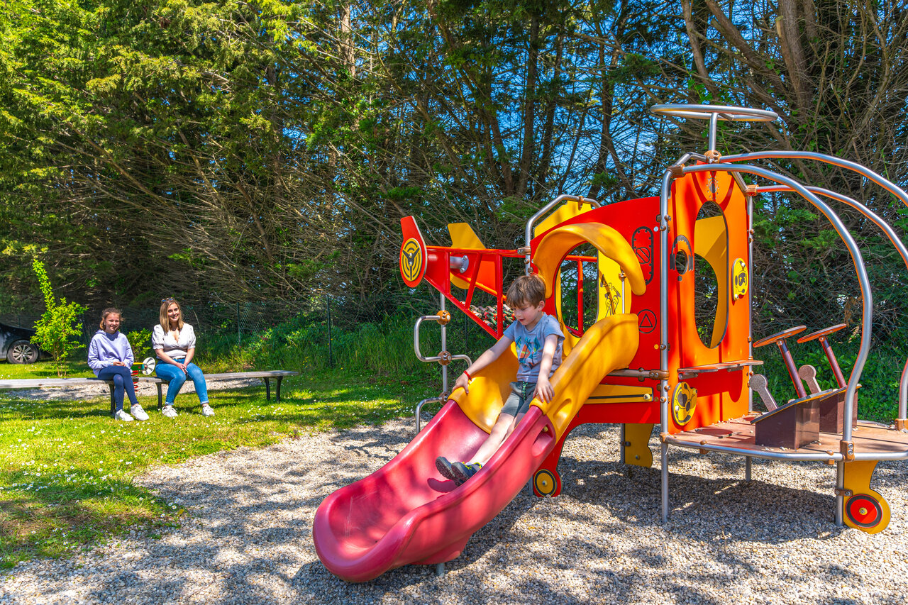Ni�o en tobog�n colorido del parque infantil en el camping CAPFUN Hautes Coutures en BENOUVILLE (14).