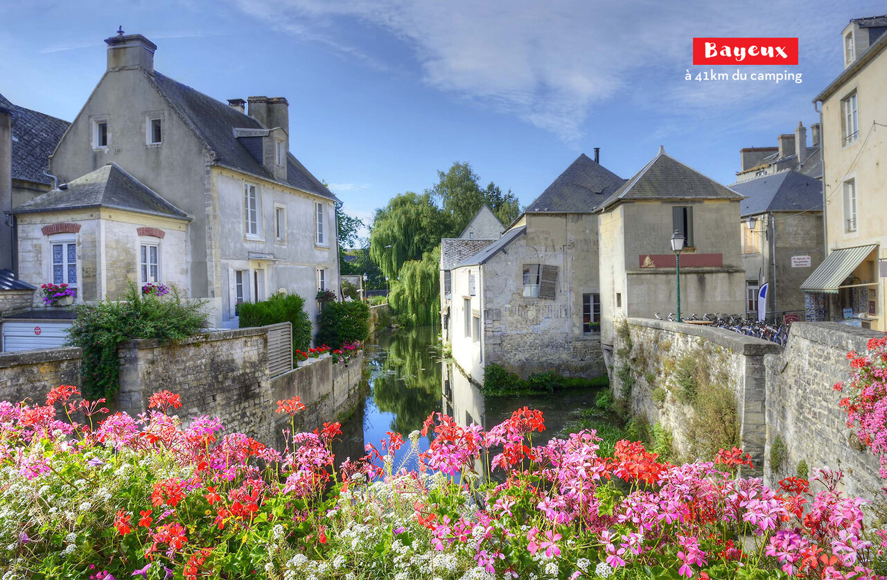 Ciudad medieval de Bayeux, casas antiguas y canal florido en Normand�a.