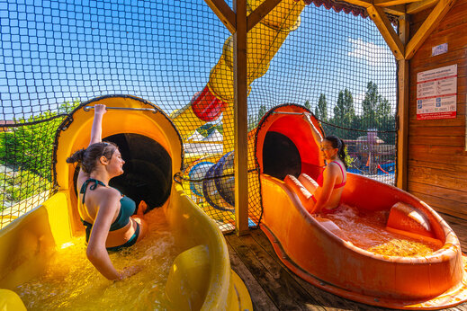 Toboganes acuáticos con jóvenes sonrientes en el camping CAPFUN Hautes Coutures en BENOUVILLE (14).
