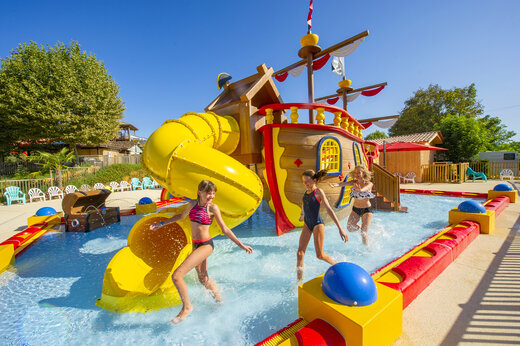 Piscina l�dica con tobog�n y barco pirata en el camping CAPFUN Hauts de Ratebout en STE FOY DE BELVES (24).