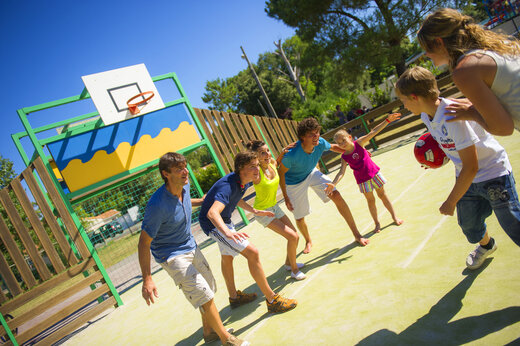 Pista multideporte con familia jugando baloncesto en camping CAPFUN Hauts de Ratebout en STE FOY DE BELVES (24).